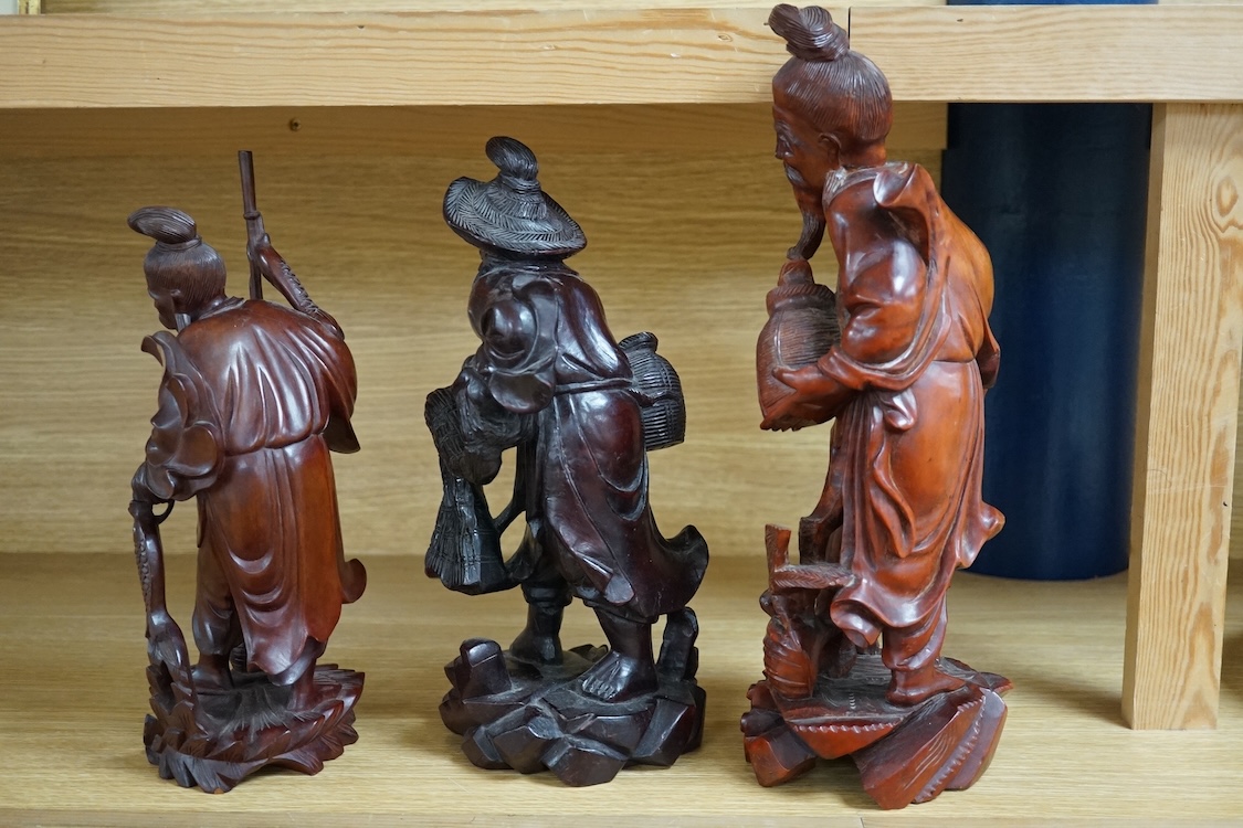 Three Chinese carved wood figures of elders, largest 37cm high